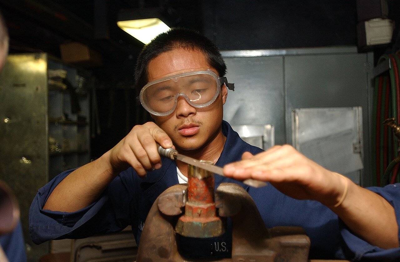 Technician preparing the end of a copper pipe for soldering